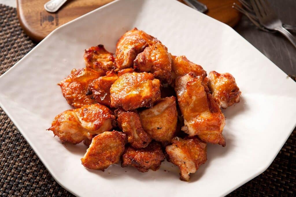 Crispy, golden-brown chicken pieces served on a white plate, showcasing a deliciously fried texture, perfect for a savory meal or appetizer.