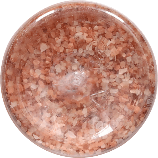 Close-up view of a container filled with Himalayan pink salt crystals, showcasing their natural color variations and texture. Ideal for cooking, seasoning, or spa use.