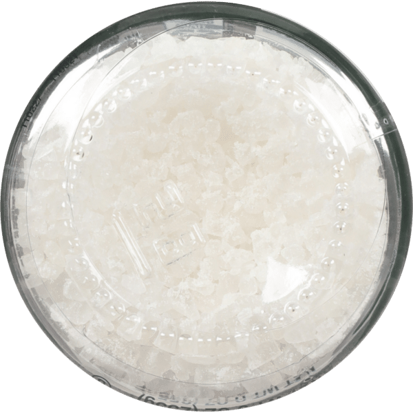 Close-up of a clear container filled with coarse white salt, ideal for cooking or seasoning dishes. The transparent lid reveals the textured salt crystals, showcasing their purity and quality.