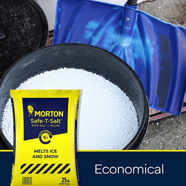 Morton Safe-T-Salt rock salt in a 25 lb bag, designed to effectively melt ice and snow, displayed in front of a bucket filled with salt and a blue snow shovel. Ideal for winter weather management and safe for use on driveways and sidewalks.