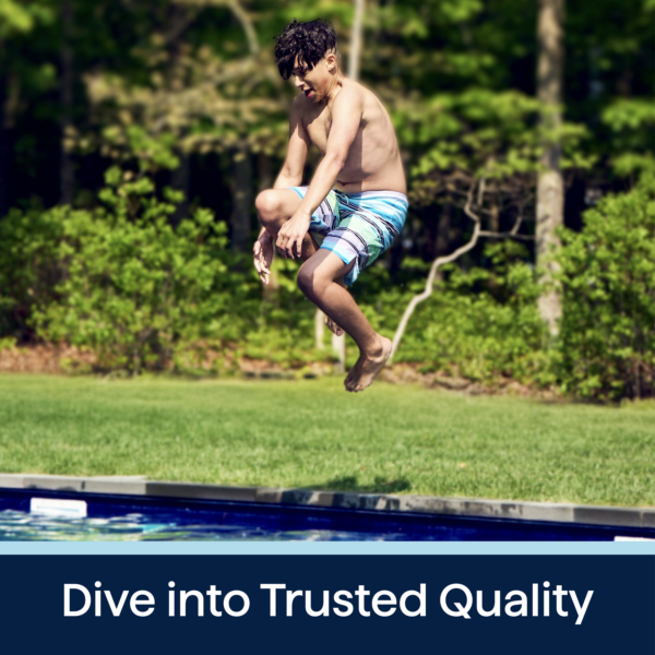 A young boy in swim trunks leaps joyfully into a swimming pool surrounded by lush greenery, showcasing a fun summer activity and highlighting quality outdoor enjoyment.