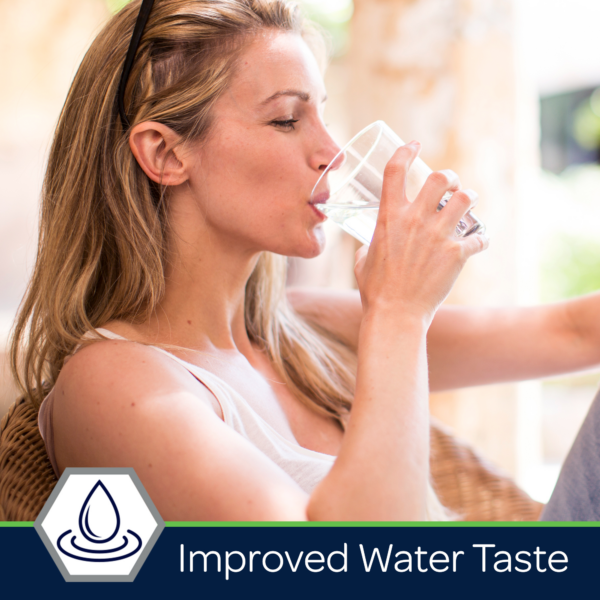 Woman enjoying a glass of clear water, highlighting the benefits of improved water taste for hydration and wellness.