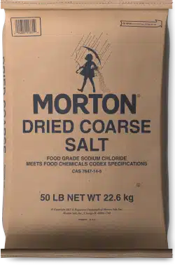 Brown paper bag of Morton Dried Coarse Salt, 50 lb (22.6 kg), featuring a graphic of a girl with an umbrella, labeled as food grade sodium chloride and compliant with food chemicals codex specifications.