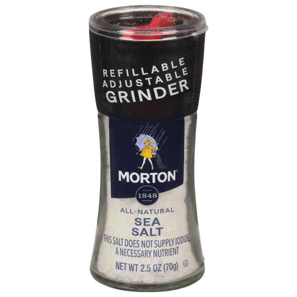 Morton all-natural sea salt in a refillable adjustable grinder, featuring a clear container with a black lid and the brand logo. The label indicates the product weight as 2.5 oz (70g) and notes that it does not supply iodide, a necessary nutrient. Ideal for seasoning dishes.