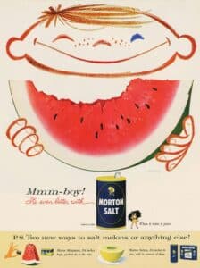 Vintage advertisement featuring a cheerful child enjoying a slice of watermelon, with a can of Morton Salt prominently displayed. The design emphasizes the message that watermelon tastes even better with salt, highlighting creative ways to enhance the flavor of melons.