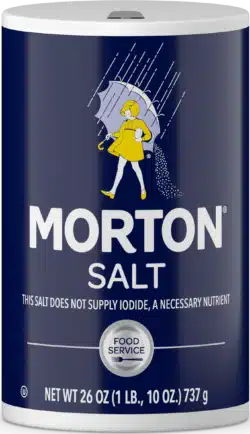 Morton Salt container featuring a vintage design with a girl holding an umbrella, labeled as 26 oz (1 lb, 10 oz) and indicating it does not supply iodide, suitable for food service use.