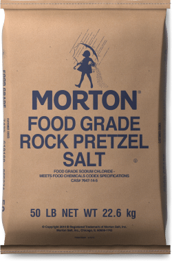 Brown paper bag of Morton Food Grade Rock Pretzel Salt, weighing 50 lbs (22.6 kg), featuring bold blue text and an illustration of a chef. The product is suitable for culinary uses and meets food chemical specifications.