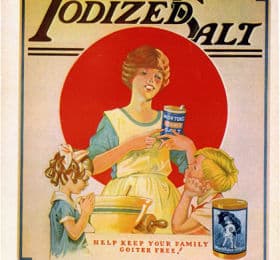 Vintage advertisement for iodized salt featuring a woman in an apron with two children. The woman holds a can of iodized salt, while one child points to it, promoting the health benefits of iodized salt in preventing goiter. The design includes bold text and a red circular background.