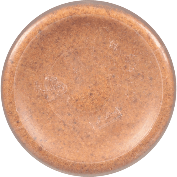 Round, transparent container filled with a brown substance, possibly a spice or cosmetic, showcasing a smooth surface and subtle texture details.