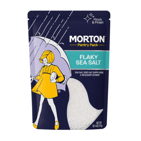 Morton Flaky Sea Salt Pantry Pack, featuring a whimsical design with a girl holding an umbrella, 6 oz packaging, ideal for seasoning and finishing dishes, emphasizes its non-iodized nature.