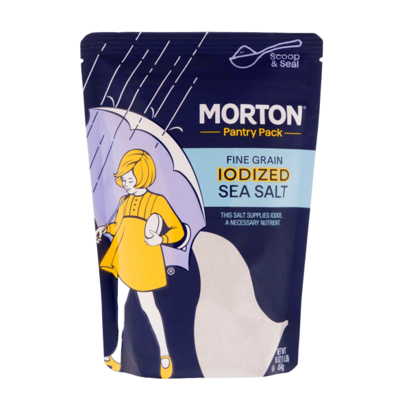 Morton Pantry Pack fine grain iodized sea salt in a resealable pouch, featuring a whimsical illustration of a child with an umbrella. The packaging highlights the product's role in supplying iodine, an essential nutrient for health.