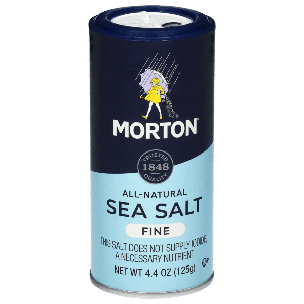 Morton All-Natural Fine Sea Salt container, 4.4 oz (125g), featuring a blue and white design with a cartoon character and the text indicating it does not supply iodide, a necessary nutrient. Ideal for enhancing flavor in cooking and baking.