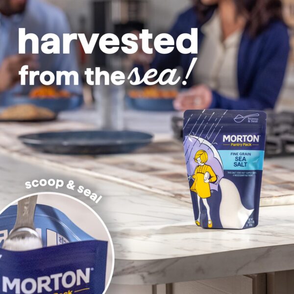 Morton Fine Grain Sea Salt Pantry Pack displayed on a kitchen table, showcasing its scoop and seal feature, with a family enjoying a meal in the background.