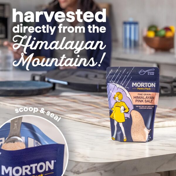 Morton Fine Grain Himalayan Pink Salt packaging on a kitchen countertop, highlighting its harvesting from the Himalayan Mountains, with a scoop and seal feature for easy use.