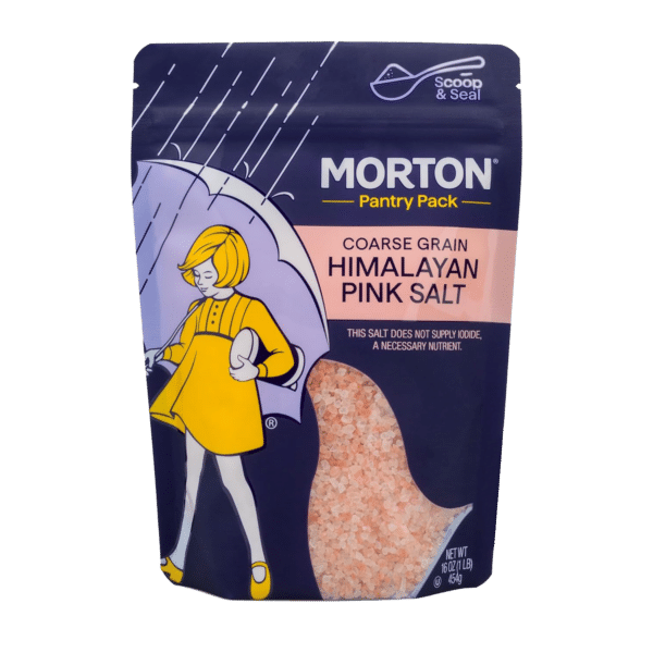 Morton Pantry Pack coarse grain Himalayan pink salt in a resealable bag, featuring a playful illustration of a girl with an umbrella. The packaging highlights its non-iodized nature and includes 16 oz (454 g) of premium salt, ideal for cooking and seasoning.